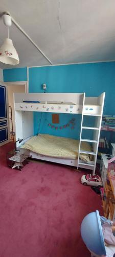 a bedroom with a bunk bed and a blue wall at Maison de ville in Rouen