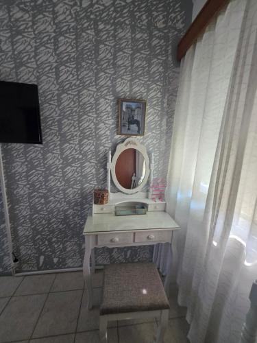 a bathroom with a sink and a mirror at Anastasia's garden house in Ialyssos