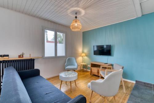 a living room with a blue couch and a tv at Céline - Belle Maison moderne in Le Petit-Quevilly