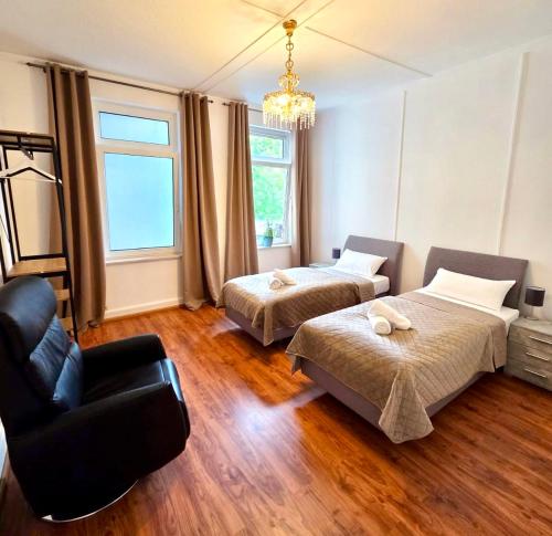 a bedroom with two beds and a couch and a chair at Ferienwohnung Fleiger 2 in Achim Zentrum in Achim