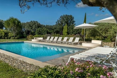 une piscine avec des chaises longues et un parasol dans l'établissement La Mas Fanny A Gordes, à Gordes