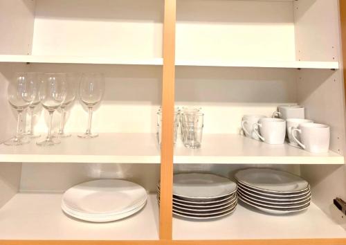 a cabinet with plates and wine glasses and dishes at Ferienwohnung Fleiger 2 in Achim Zentrum in Achim