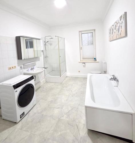 a bathroom with a tub and a sink and a microwave at Ferienwohnung Fleiger 2 in Achim Zentrum in Achim