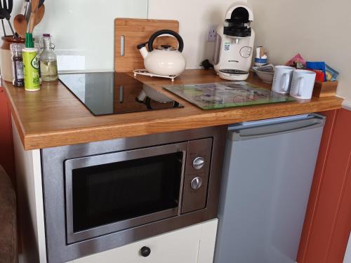 a kitchen with a counter top with a microwave at The Herdsman Luxury Shepherds Hut in Barnoldswick