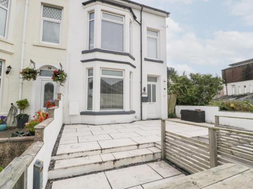 a white house with a patio and a fence at 76A Mackworth Road in Porthcawl