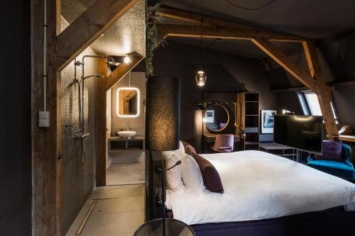a hotel room with a large bed and a bathroom at Boutiquehotel Staats in Haarlem
