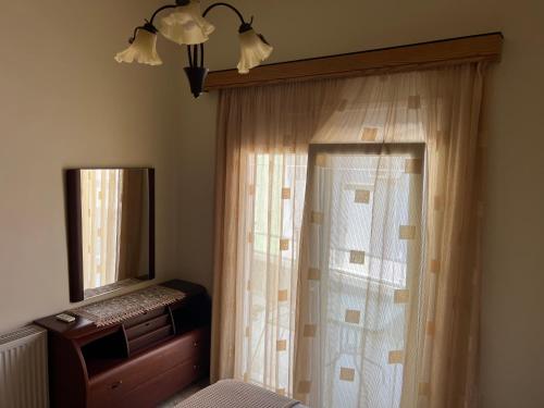 a bedroom with a curtain and a mirror and a bed at Cozy Kolonaki Retreat in Kremasti