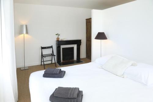 a bedroom with a white bed with two towels on it at Maison de famille in Courteuil