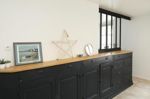 a black cabinet with a clock on top of it at Maison de famille in Courteuil