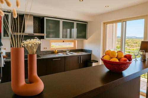 a kitchen with a bowl of fruit on a table at Golf - Vale Da Pinta T2 com Piscina, Wi-Fi e Ar Condicionado in Carvoeiro