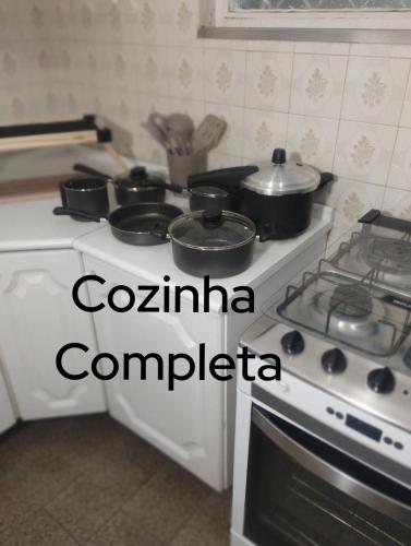a kitchen with a stove with pots and pans on it at IDEAL Hotel Confort Suite in Piracicaba