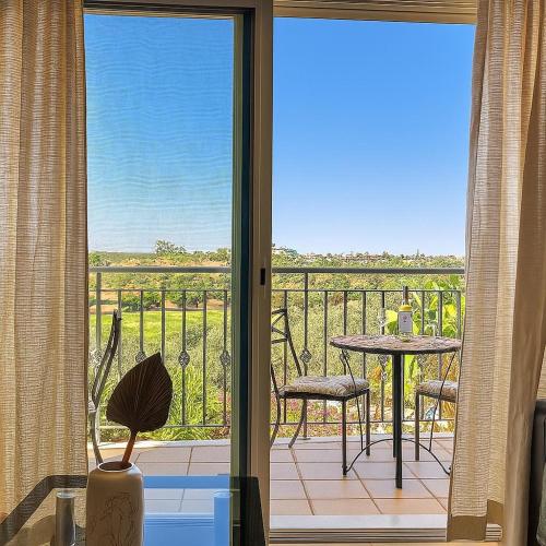 a room with a balcony with a table and a view at Golf - Vale Da Pinta T2 com Piscina, Wi-Fi e Ar Condicionado in Carvoeiro