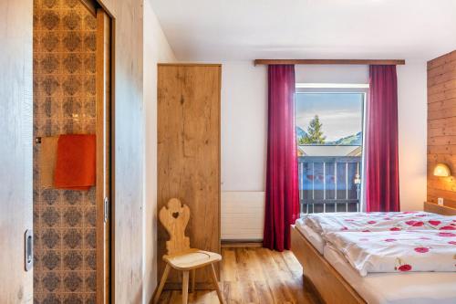 a bedroom with a bed and a window at Pension Heidelberg in Hopfgarten im Brixental