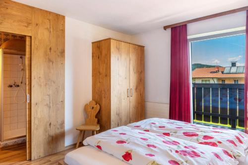 a bedroom with a bed and a window at Pension Heidelberg in Hopfgarten im Brixental