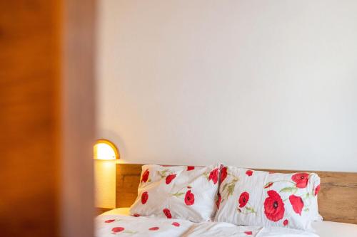 a bed with a pillow with red flowers on it at Pension Heidelberg in Hopfgarten im Brixental