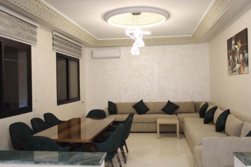 a living room with a couch and a table and chairs at Larache haut standing in Larache