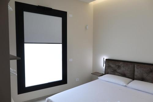 a bedroom with a bed with a large window at DR Luxury Apartments in Avola