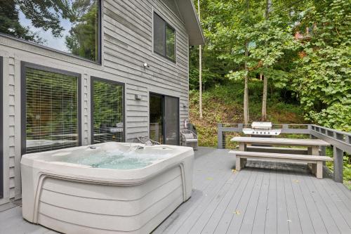 a bath tub sitting on a deck with a bench at Experience luxury at Smoky Mountain Hideaway, just 5 miles from downtown Gatlinburg in Gatlinburg