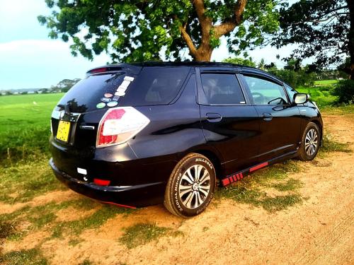 a black car parked on the side of a dirt road at Green Bamboo House in Sigiriya