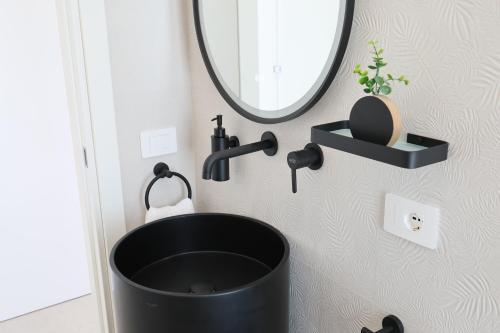 a bathroom with a black sink and a mirror at DR Luxury Apartments in Avola