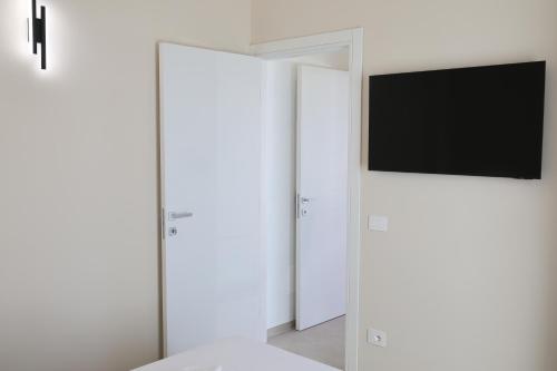 a bedroom with a tv on a white wall at DR Luxury Apartments in Avola