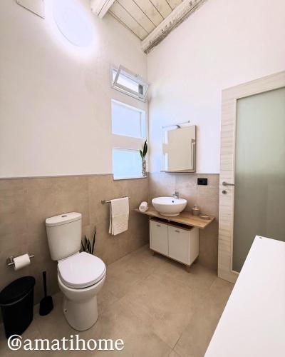 a bathroom with a toilet and a sink at Amati home in Floridia