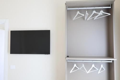 a tv and hangers in a room with a television at DR Luxury Apartments in Avola