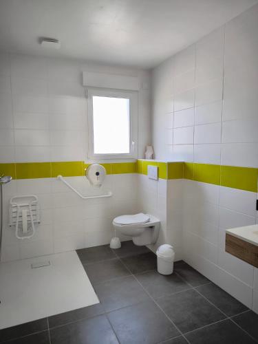 a bathroom with a toilet and a sink at Village Vacances Les Sables d'Or in Gouville-sur-Mer