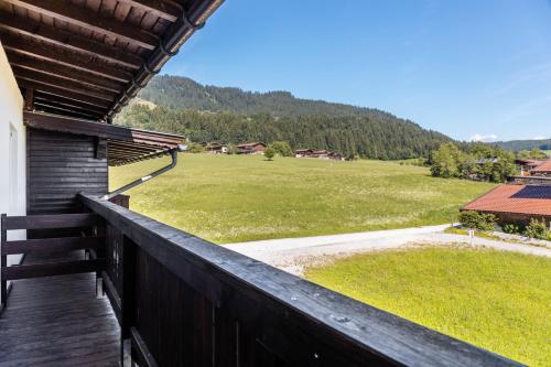 a balcony of a house with a view of a field at Pension Heidelberg in Hopfgarten im Brixental