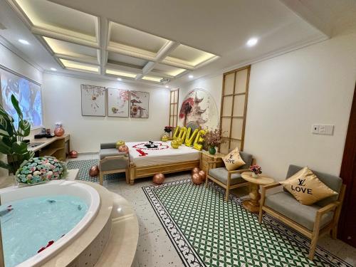 a living room with a tub and a bed and a couch at Love Luxury Hotel Vườn Lài in Ho Chi Minh City