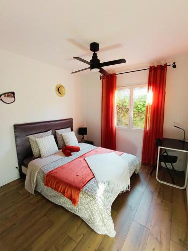 une chambre avec un lit et une fenêtre avec des rideaux rouges dans l'établissement Au Pied De La Colline calme et détente Pézenas, à Pézenas