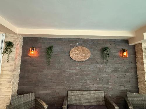 a room with a brick wall with chairs and lights at Pensiunea Select Moeciu in Moieciu de Sus