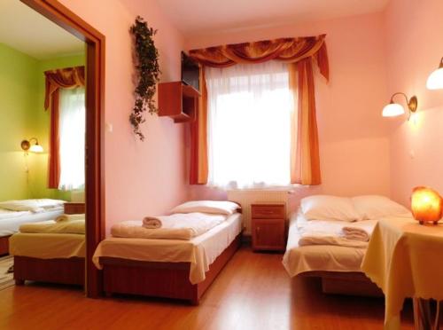 - une chambre avec 2 lits et un grand miroir dans l'établissement Willa na Stoku, à Krynica-Zdrój