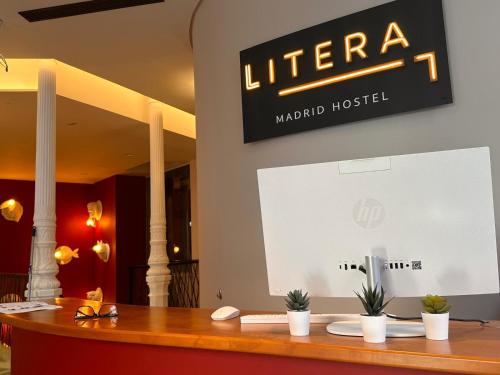 a sign for a hotel with plants on a table at Literal Hostel Madrid in Madrid