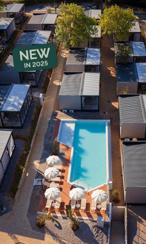 an overhead view of a pool with white chairs and a swimming pool at Aminess Style Glamping Villas & Holiday Homes Atea in Njivice
