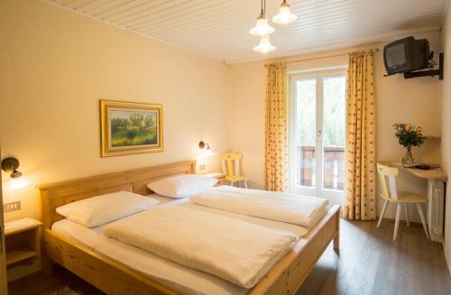 a bedroom with two beds and a window at Berghotel Kason in Predoi