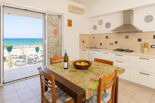 a kitchen with a table with a bowl of fruit on it at Villa Mirage in Alcamo