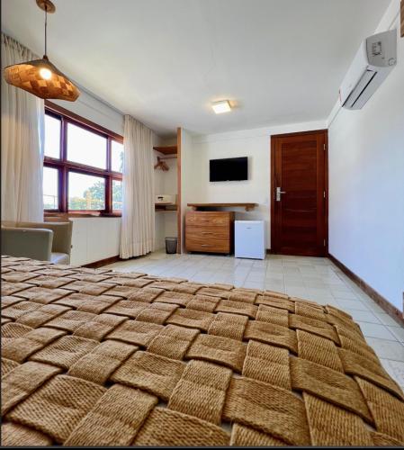 a large bedroom with a large bed and a television at Pousada Manga Rosa Beira Mar in Natal