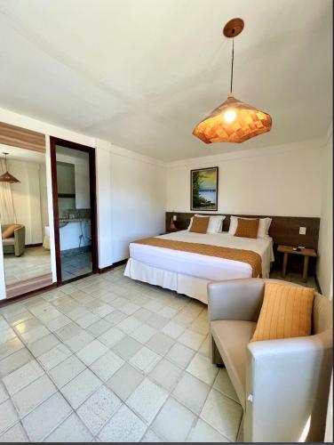 a bedroom with a bed and a couch in it at Pousada Manga Rosa Beira Mar in Natal