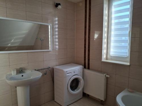 a bathroom with a washing machine and a sink at Mazurski Spokój 