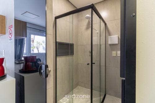 a shower with a glass door in a bathroom at Estúdio Modernos em Condomínio com Piscina em Floripa - ASK in Florianópolis