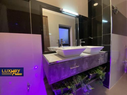 a purple bathroom with two sinks and a mirror at Luxury Palace 