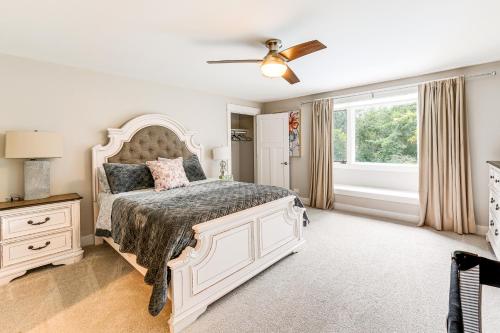 a bedroom with a large white bed and a window at 7,100 Sq Ft Retreat with Gazebo and Koi Pond in Wayne! 