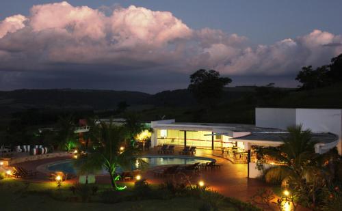 a building with a swimming pool at night at Hotel Boutique Frangipani in Brotas