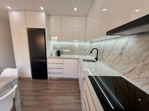 cocina con encimeras de mármol y nevera en Casas Castelhano - Minho Braga, en Mire de Tibães