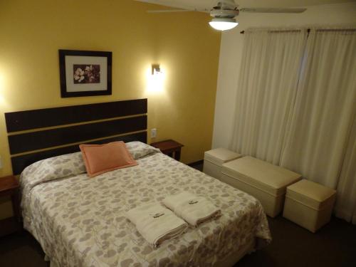 a bedroom with a bed with two towels on it at Hotel Holimasú in Colón