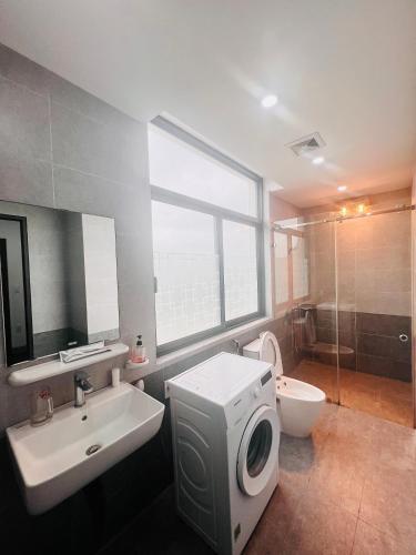 a bathroom with a sink and a washing machine at HPT Home II Vinhome Marina chuỗi Apartment - Homestay in Hai Phong
