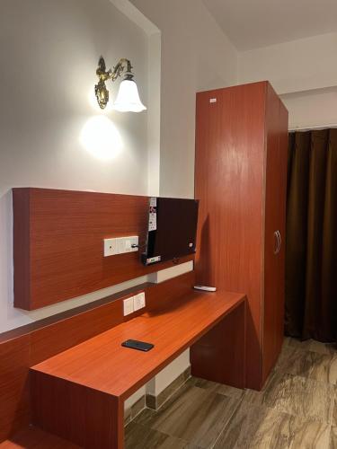 a room with a desk with a television on it at Stay Heights near Expo mart in Greater Noida