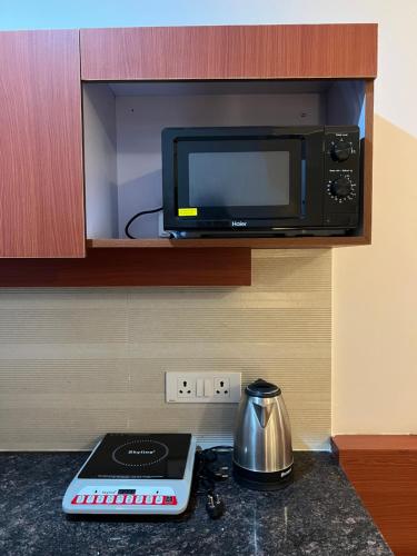 a microwave oven sitting on top of a kitchen counter at Stay Heights near Expo mart in Greater Noida