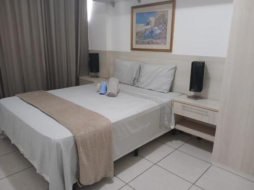 a bedroom with a large white bed and a television at Barra Rio Centro in Rio de Janeiro